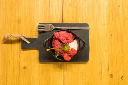 a plate of food on a table with a fork at Maison La Saxe in Courmayeur