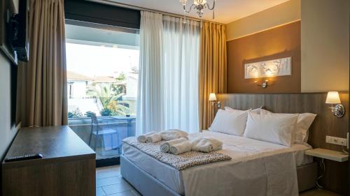 sypialnia z łóżkiem z dwoma ręcznikami w obiekcie Agnes Deluxe Hotel w mieście Pefkochori