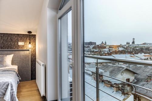 a bedroom with a bed and a large window at InshiApartments on Hazova str 5 in Lviv
