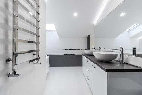a bathroom with two sinks and white walls at InshiApartments on Hazova str 5 in Lviv