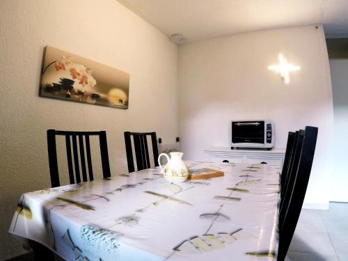 a dining room table with a white table cloth on it at Studio plein sud, Wifi, Parking in Thollon