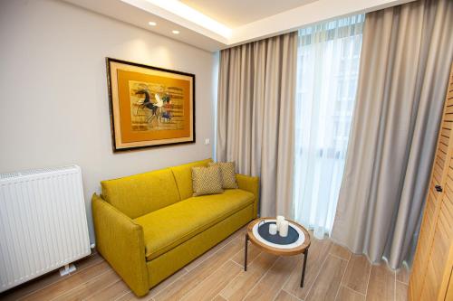 a living room with a yellow couch and a table at No21 Luxury Suites in Thessaloniki