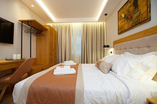 a hotel room with a large bed and a desk at No21 Luxury Suites in Thessaloniki