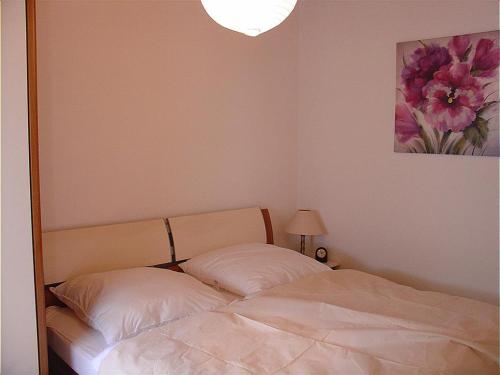 ein Schlafzimmer mit einem Bett und einem Blumengemälde an der Wand in der Unterkunft Type Scout 42 in Ronshausen