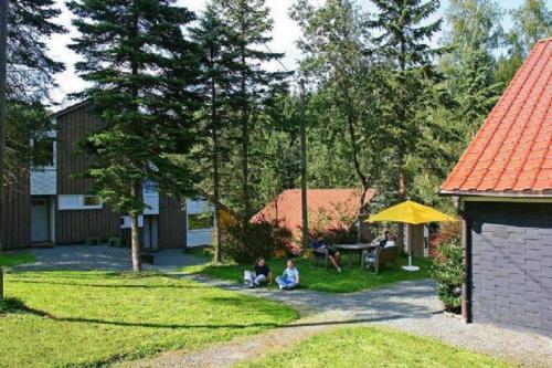 zwei Leute sitzen im Gras auf einem Hof in der Unterkunft Typ Murmeltier in Schmallenberg