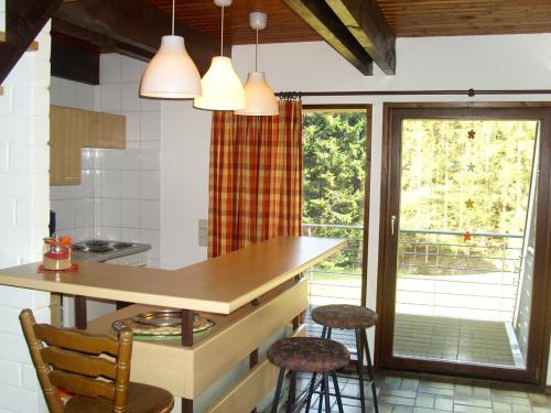 a kitchen with a counter and two stools in it at Typ Dachsbau in Schmallenberg