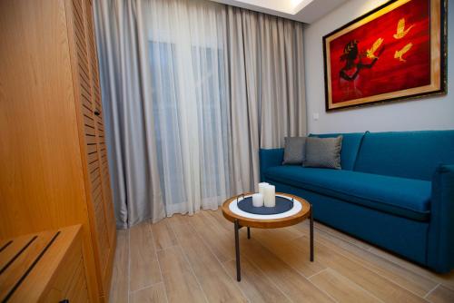 a living room with a blue couch and a table at No21 Luxury Suites in Thessaloniki