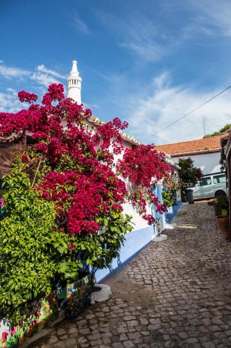 a bunch of flowers on a wall with a lighthouse at AlvorMar Apartamentos Turisticos in Alvor