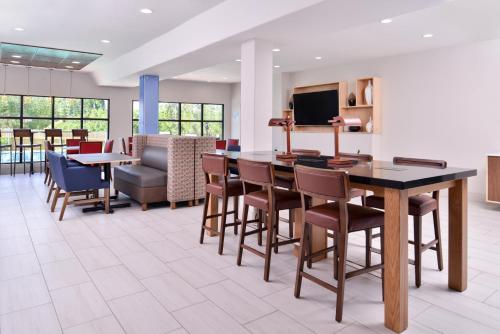 a lobby with a table and chairs and a couch at Holiday Inn Express Hotel & Suites Elgin by IHG in Elgin