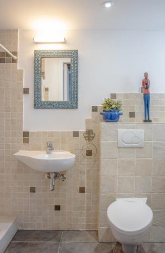 a bathroom with a sink and a toilet and a mirror at The Carob Tree Villa - Rustic Luxury Home With Access To Pool And Restaurant in Larnaka
