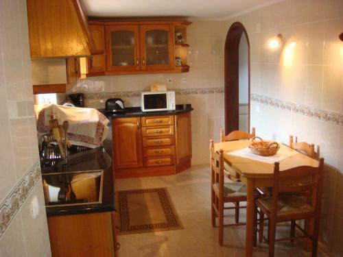 a kitchen with a table and a kitchen with a microwave at Casa De Hospedes Flor Do Jardim in Malveira