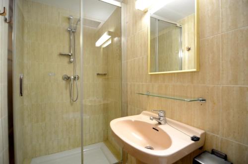 een badkamer met een wastafel en een glazen douche bij VALL GRAN 2 in L'Estartit