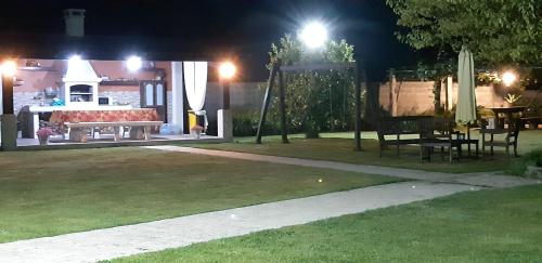 un parc de nuit avec un banc et une table dans l'établissement Hotel Cachada, à Sanxenxo