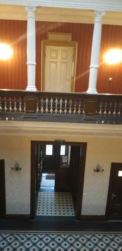 a hallway in a building with a door and columns at Schlossgut Gorow in Satow