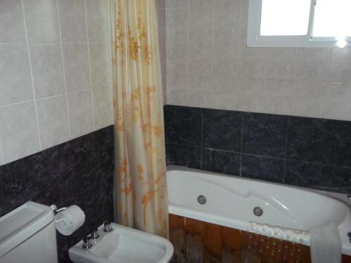 a bathroom with a tub and a toilet and a sink at La Posada del Mar in Miramar