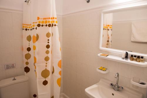 a bathroom with a shower curtain and a sink at Lefkothea Hotel in Kamari