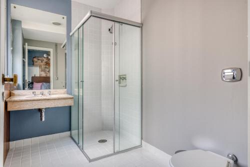 een badkamer met een glazen douche en een wastafel bij Selina Aurora Sao Paulo in Sao Paulo