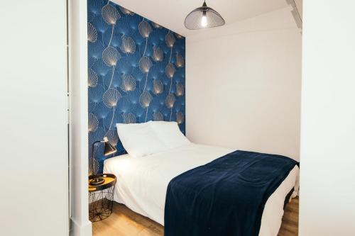 - une chambre dotée d'un lit avec un mur bleu dans l'établissement Studio Méan near Airbus and Chantiers Atlantique - wifi - parking, à Saint-Nazaire