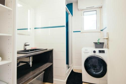 La salle de bains est pourvue d'un lave-linge et d'un lavabo. dans l'établissement Studio Méan near Airbus and Chantiers Atlantique - wifi - parking, à Saint-Nazaire