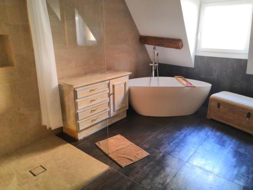 une salle de bain avec une baignoire blanche et un lavabo dans l'établissement Au Grenier de La Grenouille, à Colmar
