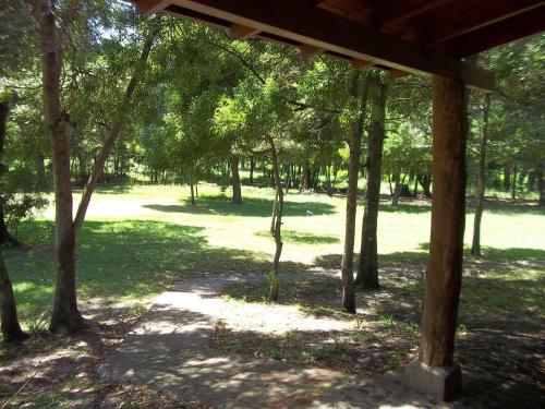 a wooden pavilion in a park with trees at La Posada del Mar in Miramar