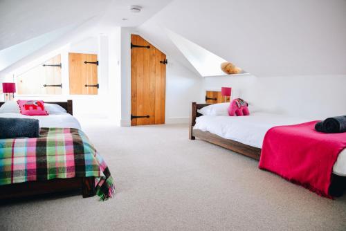 um quarto com 2 camas e um sótão em Chichester Cottage em Funtington