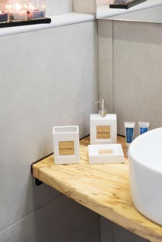 a bathroom with a sink and two boxes on a wooden counter at KORINA APART HOTEL KAVOS in Kavos
