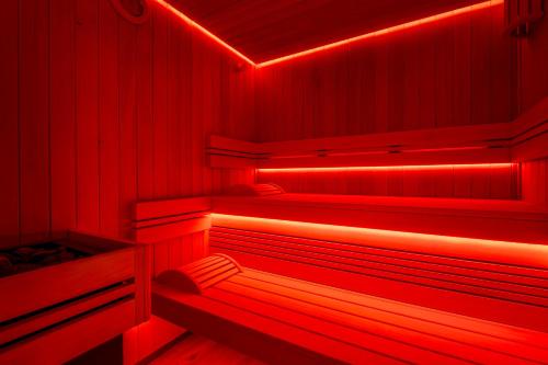 an empty sauna with red lights in it at Résidence Pierre & Vacances Premium L'Hévana in Méribel