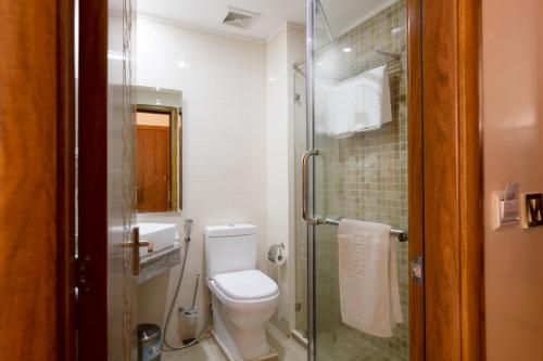 a bathroom with a toilet and a glass shower at Saab Royale Hotel in Nairobi