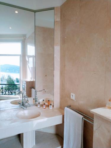une salle de bain avec un lavabo et un grand miroir dans l'établissement Semiramis, à Villefranche-sur-Mer