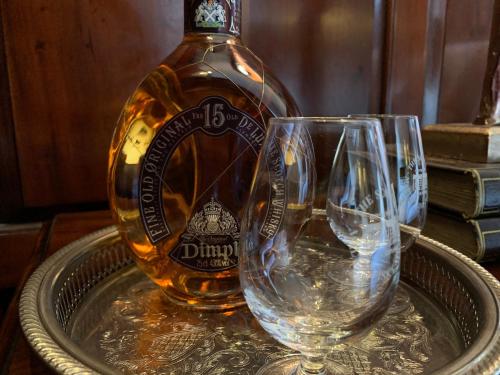 two wine glasses on a tray with a bottle of alcohol at 23 Mayfield in Edinburgh