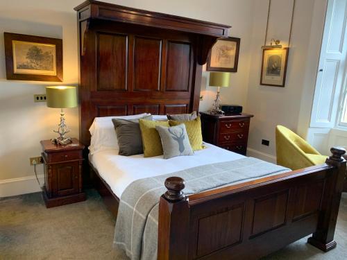 a bedroom with a large bed with a wooden headboard at 23 Mayfield in Edinburgh