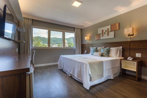 a hotel room with a bed and a window at Hotel Villa Fiori in Poços de Caldas