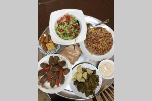 a table with three plates of food and a salad at Wonderful near Ram lake and Hermon mountain in Mas'ade