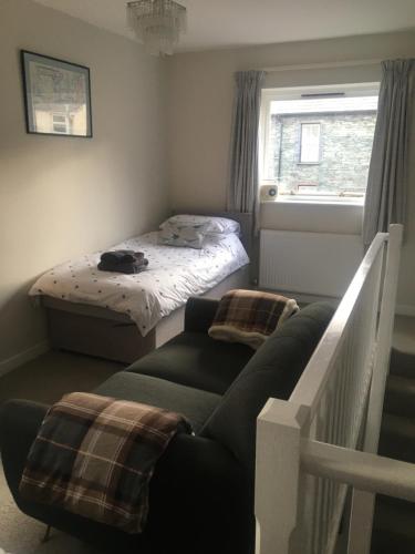 a small bedroom with a bed and a couch at Self-Contained Accommodation for 2 in Keswick