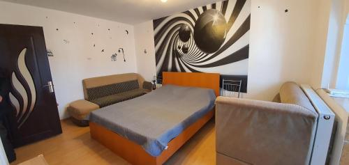 ホレズにあるGarsoniera Horezuのベッドルーム1室(ベッド1台、椅子、絵画付)