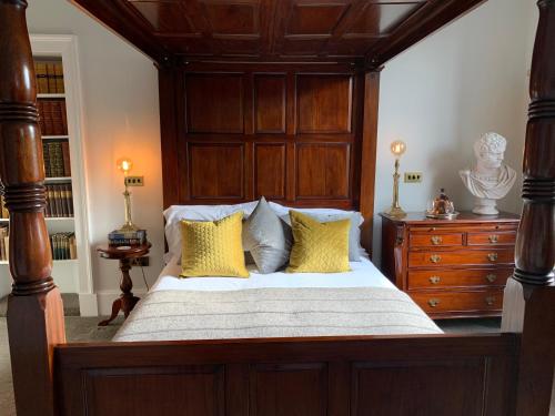 a bedroom with a large wooden bed with yellow pillows at 23 Mayfield in Edinburgh