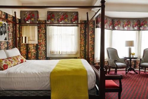 a bedroom with a bed and chairs in a room at White Swan Inn in San Francisco