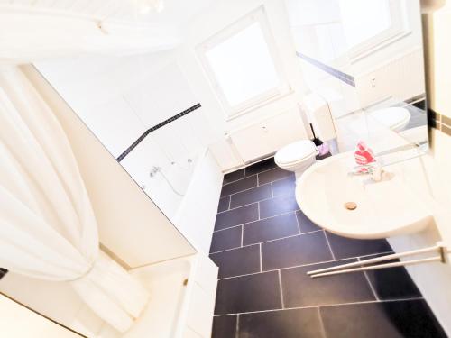 a bathroom with a white sink and a toilet at Ferienwohnung Mila in Grevenkop