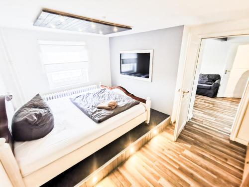 a small bedroom with a bed and a television at Ferienwohnung Mila in Grevenkop