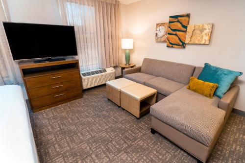 a living room with a couch and a flat screen tv at Staybridge Suites Coeur d'Alene by IHG in Coeur d'Alene