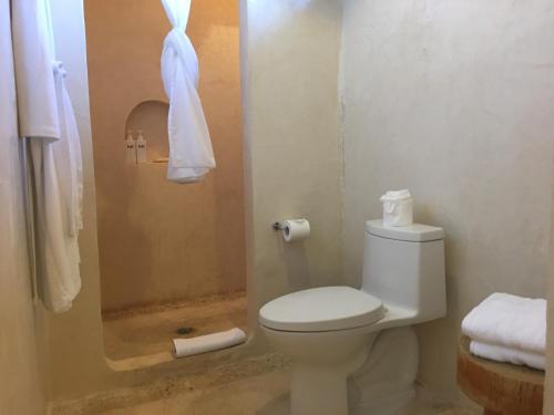 a bathroom with a white toilet and a shower at Hotel Casa HX - Adults Only in Holbox Island
