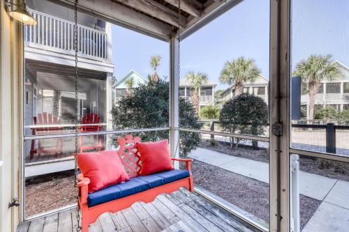 a screened porch with a red and blue couch at Gone Coastal B23 in Highland View