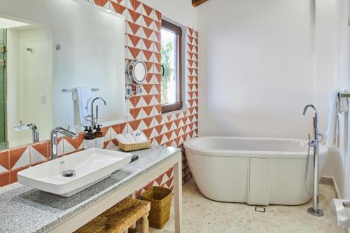 a bathroom with a large tub and a sink at Hotel Luxury Patio Azul in Puerto Vallarta