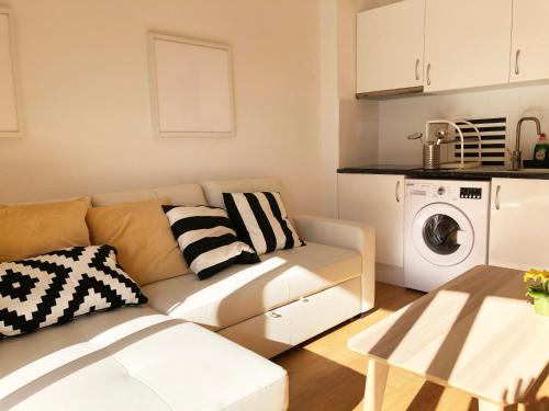ein Wohnzimmer mit einem Sofa und einer Waschmaschine in der Unterkunft Lovely seaside apartment in front of Calafell beach and Cunit beach in Segur de Calafell