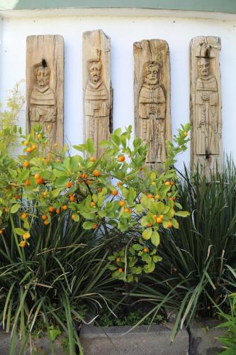 a group of statues on a wall with plants at La Casa del Atrio in Querétaro