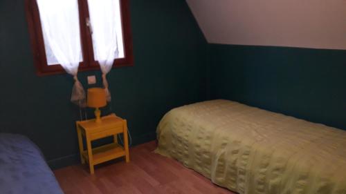 a green bedroom with a bed and a window at Le Pech de Sireuil in Groléjac