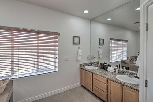 a bathroom with two sinks and a large mirror at Desert Condo with Pool about 3 Miles to Colorado River! in Bullhead City