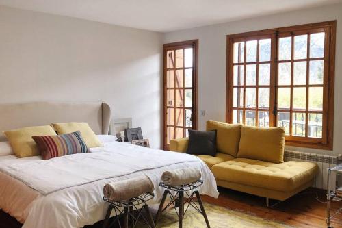 sypialnia z dużym łóżkiem i żółtą kanapą w obiekcie Casa Daniela w mieście Castejón de Sos