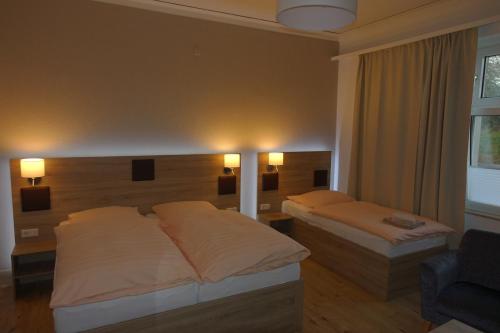 a hotel room with two beds and a window at Gasthof & Restaurant "Am Kreuz" in Essen